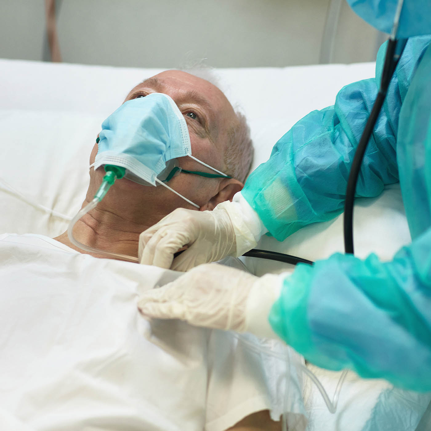 Man laying in hospital bed receiving supplemental oxygen